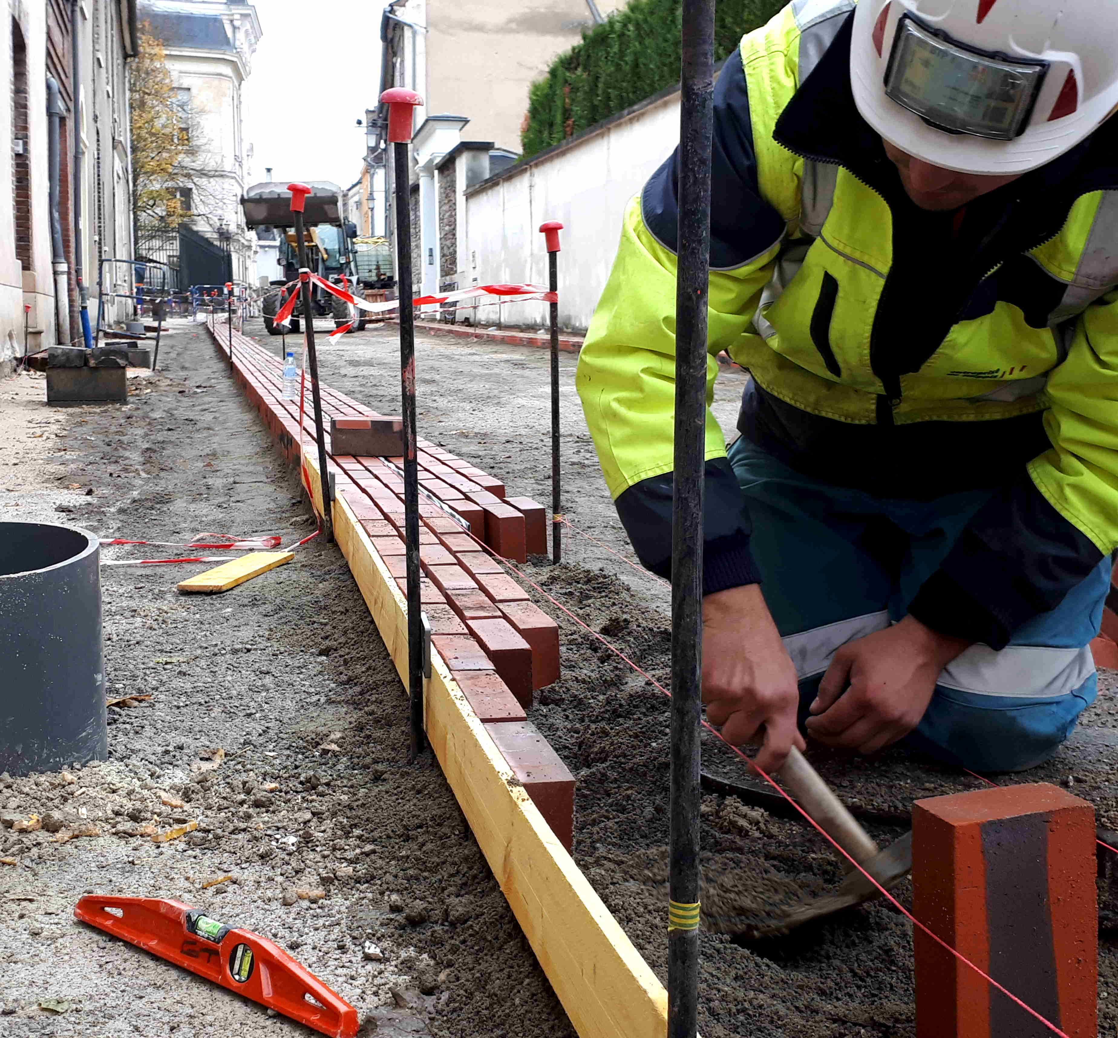 Poseurs à l'oeuvre : la précision dans les alignements - réalisation de bandes structurantes en briques - pose sur chants